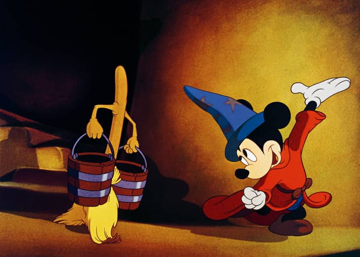 Mickey Mouse dancing with a broomstick carrying buckets of water.