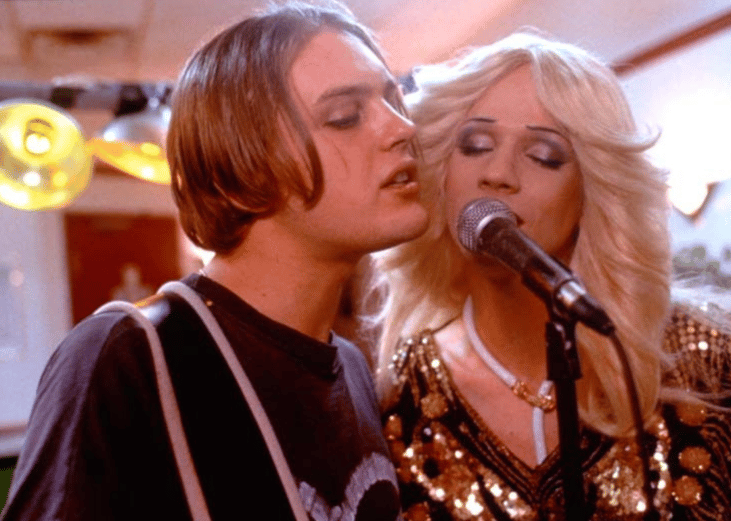 Two people singing at a microphone.