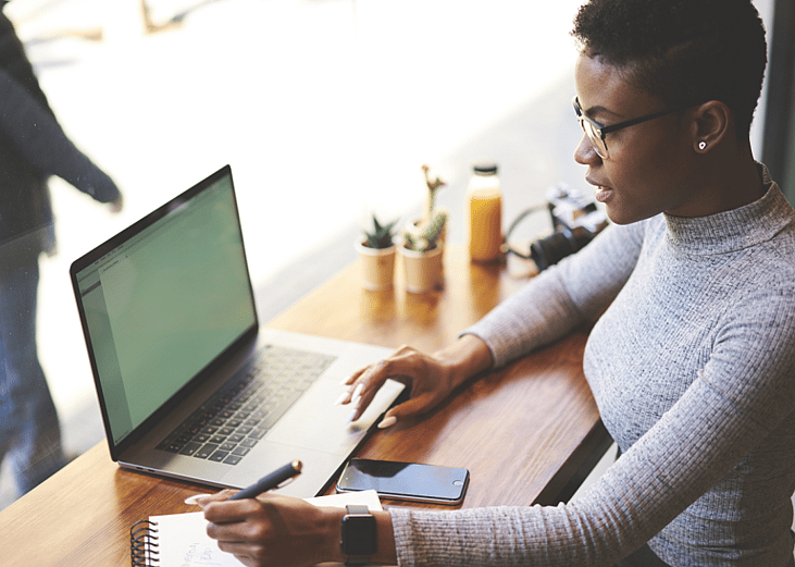 A woman works on a laptop in a cafe.