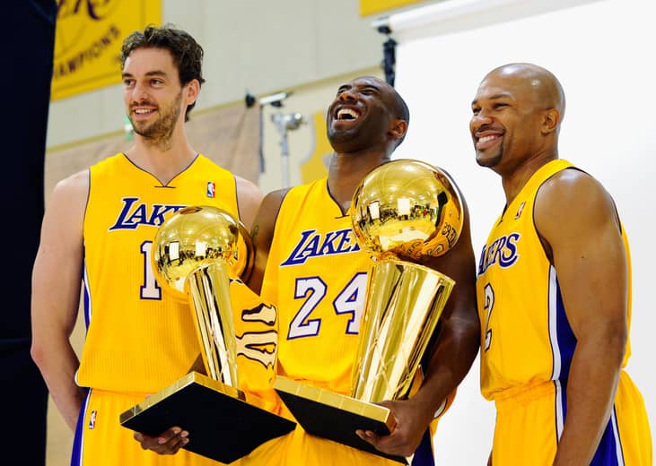 Kobe Bryant laughs as he holds two NBA Finals Trophy's with teammates Pau Gasol and Derek Fisher. 