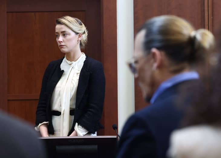 Amber Heard testifies as actor Johnny Depp looks on.