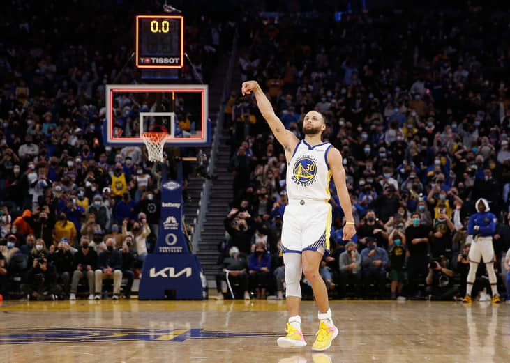 Wide view of Stephen Curry right after he shot, scoreboard in background