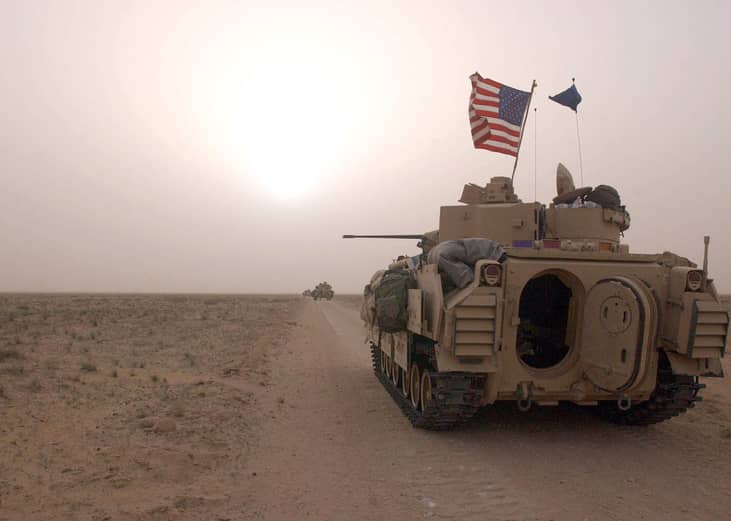 U.S. Army 3rd Division 3-7 Bradley fighting vehicles take up a position along a road.