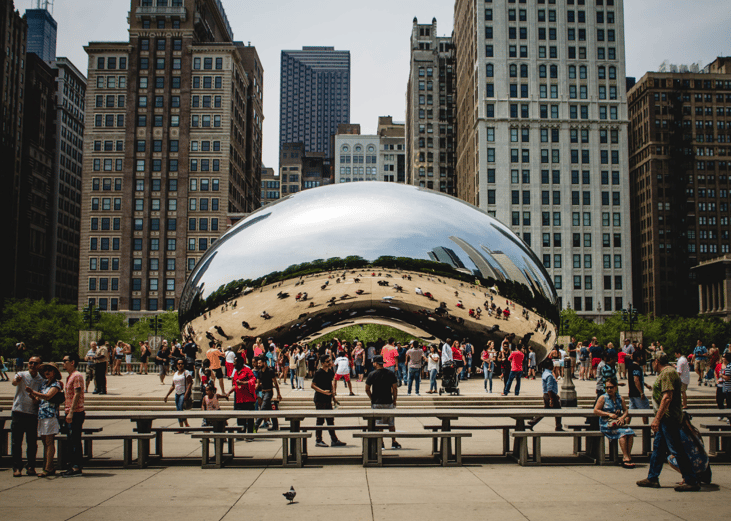 The bean landmark crowded with people in Chicago.