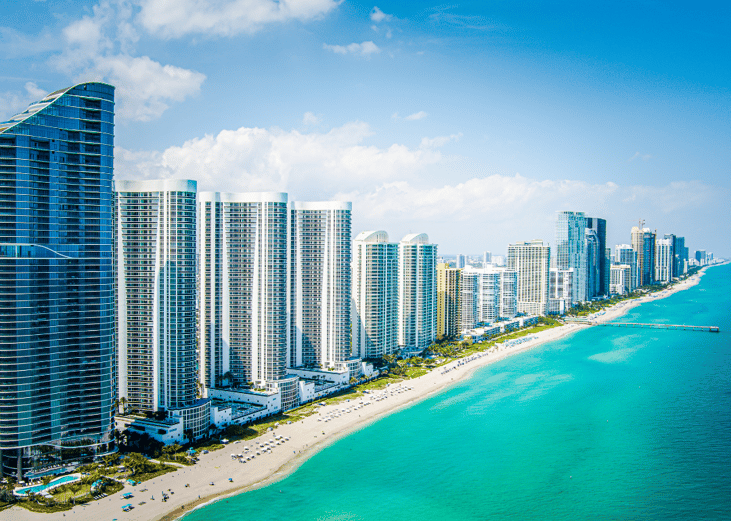 Tall beachfront condos and hotels along the turquoise water in Miami, Florida.