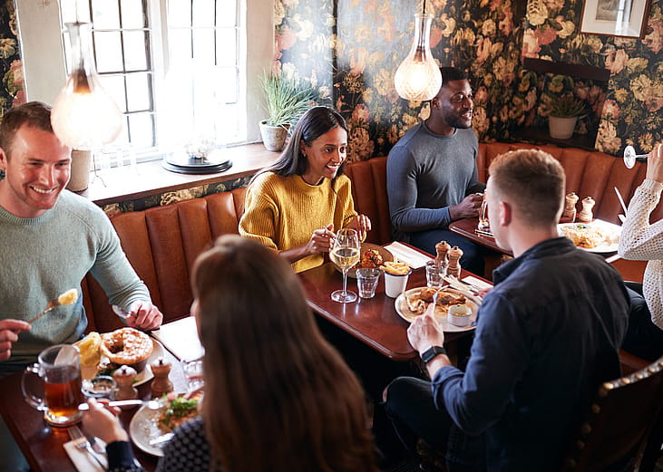 Three sets of people eating in a restaurant.