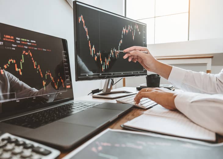 Man pointing to and analyzing stock market graph.