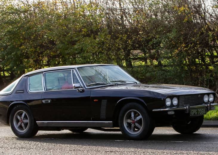 1970s Jensen Interceptor car driving on an English country road.