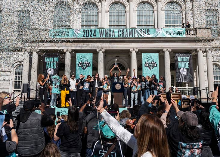 Members of the New York Liberty team celebrate their championship at a ticker tape parade.