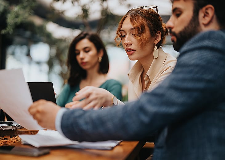 Three startup business colleagues discussing during a casual coffee meeting.