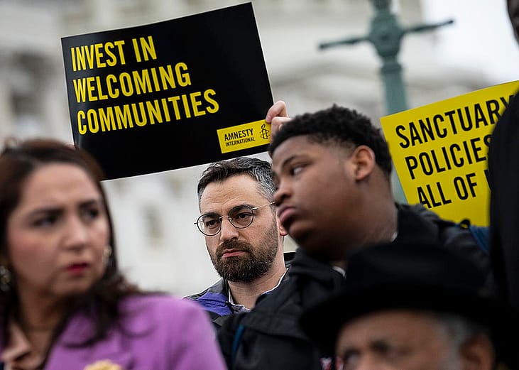 People hold signs in support of sanctuary city mayors outside the U.S. capitol, on Wednesday, March 5, 2025 in Washington, D.C.