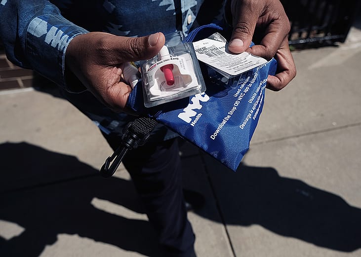 A Services for the UnderServed (S:US) worker holds a naloxone overdose kit.