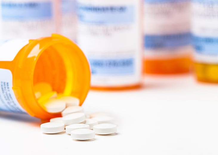 Prescription tablets spilling from bottle.