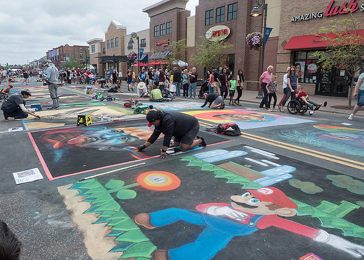 Chalk artists creating art during the Chalk Art Festival in Maple Grove, Minnesota.