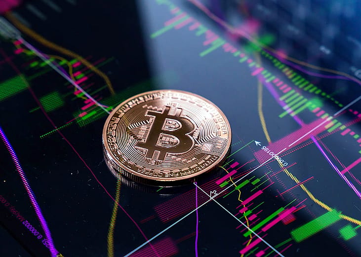 Gold bitcoin on top of finance graphic charts.