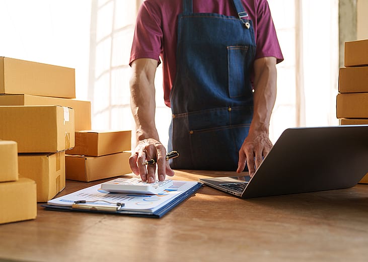 Small business owner calculating orders.