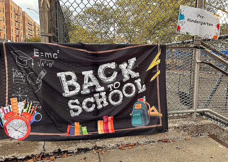 A black "Back to School" banner hangs outside a New York pre-school enrolling a pre-kindergarten class.