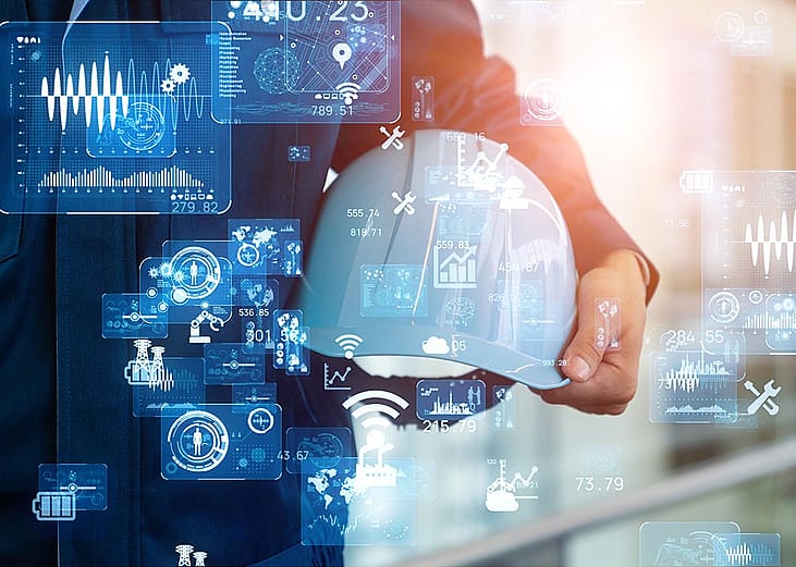 White hard hat held in the crook of a person's arm with technology icons superimposed symbolizing AI advance and sautomation of manufacturing processes using computers and electronics.