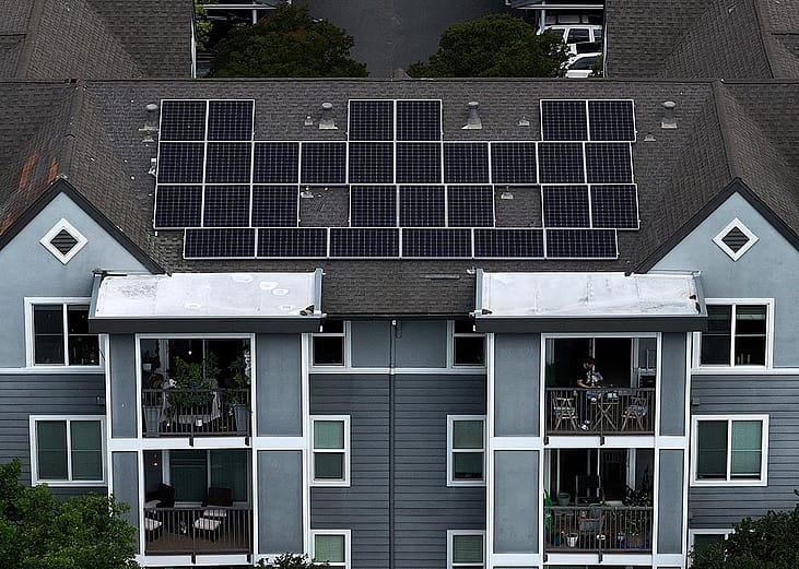Aerial view of solar panels are on the roof of an apartment complex in California.