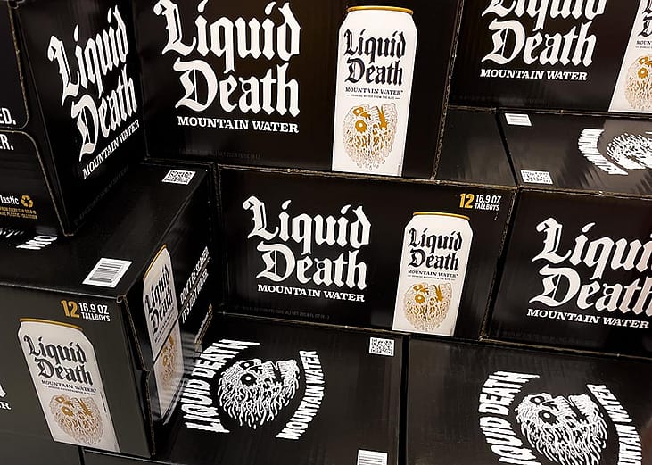 Black boxes of Liquid Death canned mountain water grocery store display.
