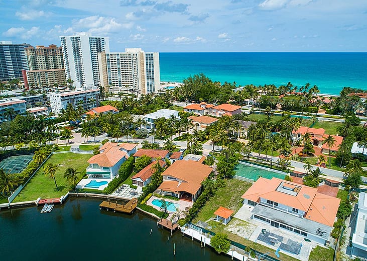 Aerial shot of luxury Miami homes with ocean in background.