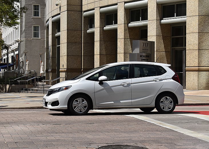A white Honda Fit EX-L FWD car in downtown Houston, Texas.