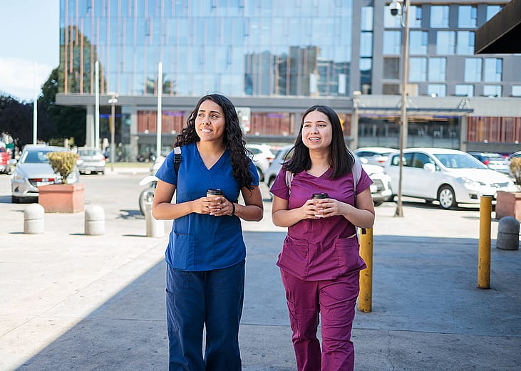 Two young female nurses having coffee after work.