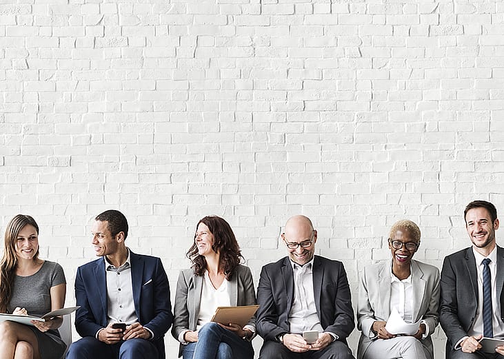 Professionals lined up sitting for a job interview.