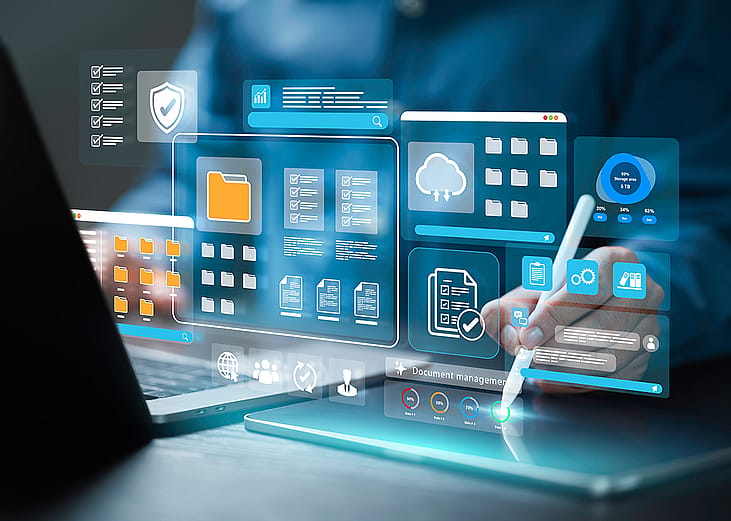 Employee working on a laptop with holographic illustrations of document management software concepts.