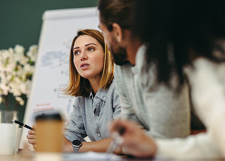 Businesswoman having a discussion with her colleagues in a meeting room.