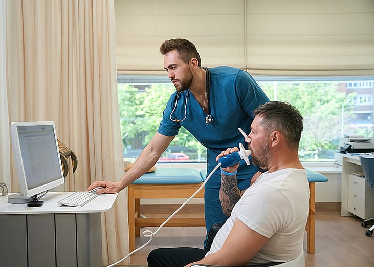 A pulmonologist checking a patient's lung functions during a spirometry test.