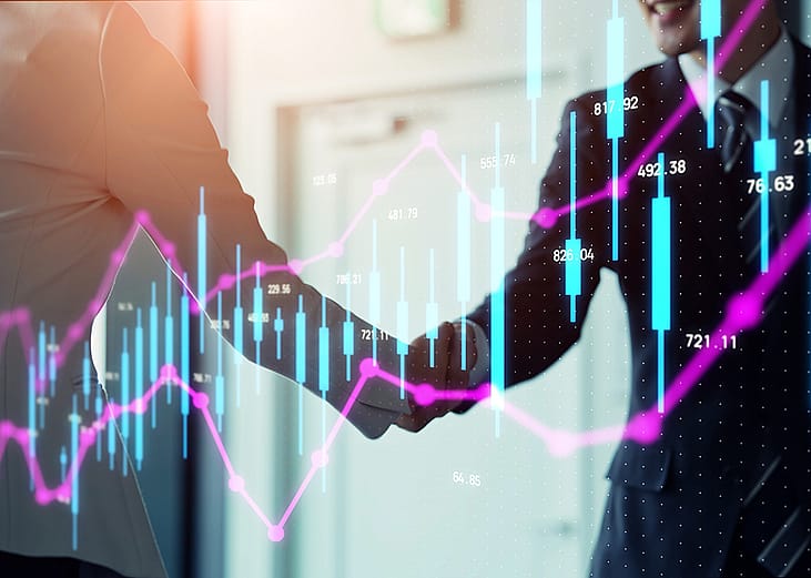 Stock chart graphics over business people shaking hands.