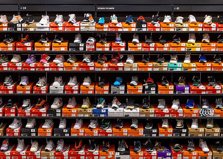 Various styles and models of Nike shoes neatly displayed on store shelves.