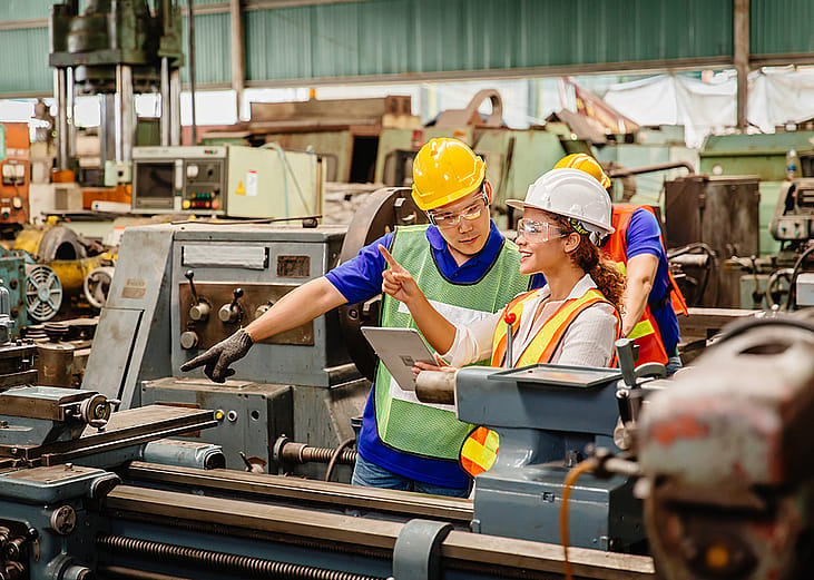 Heavy industry machine workers coordinating on site.