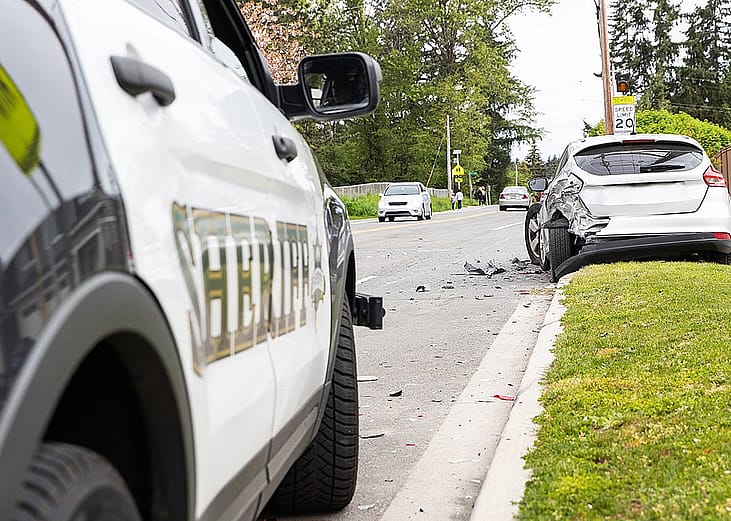 A car crash on the side of a street from the point of view of a sheriff's car.