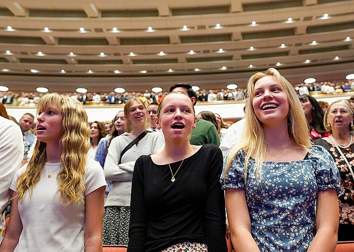 Low angle view of young women singing a hymn during a session of General Conference of The Church of Jesus Christ of Latter-day Saints in April 2025. 