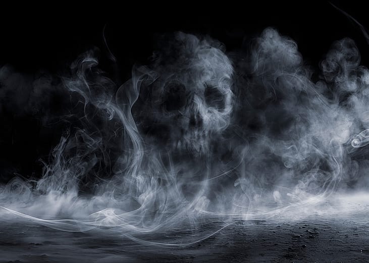 Fog forming a figure of a skull on dark background.