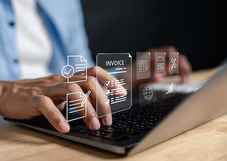 Business expense software concept using invoice graphics illustrated over a person using a laptop.