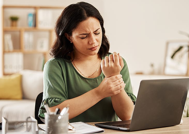 A female employee working from home having wrist aches.