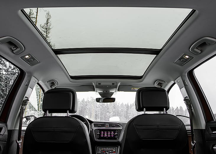 A backseat view of a panoramic roof of a car.