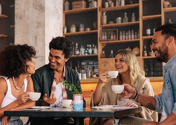 A group of friends having coffee together in a cafe.