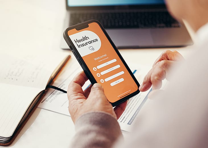 A senior person browsing a health insurance app on a smartphone.