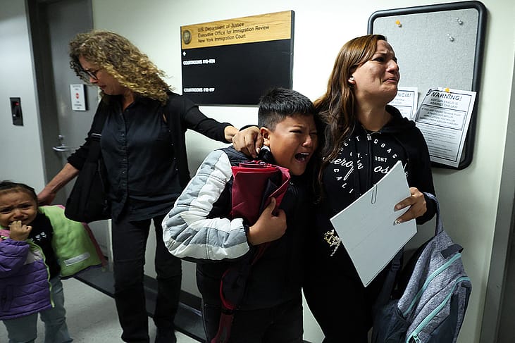 A wife and her children crying as her husband is detained by federal agents outside a New York Federal Plaza Immigration Court room in New York City.