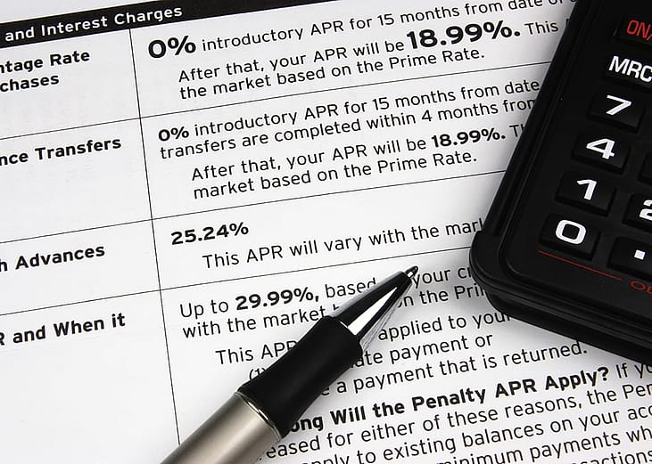 A pen and calculator on top of a credit terms report.