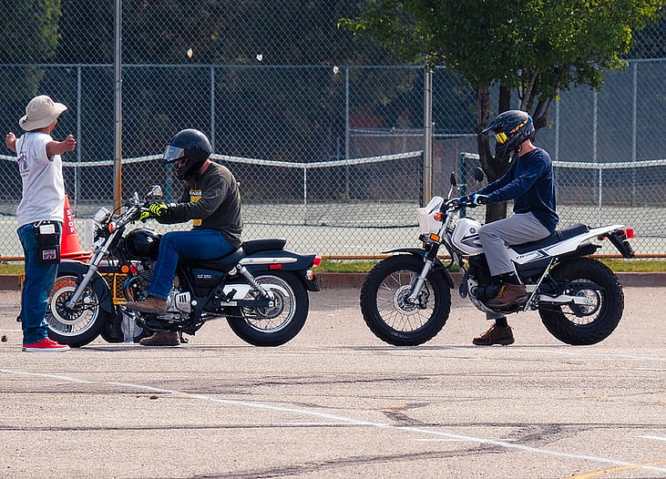 Beginning motorycle riders learn riding lessons at a motorcycle safety class.