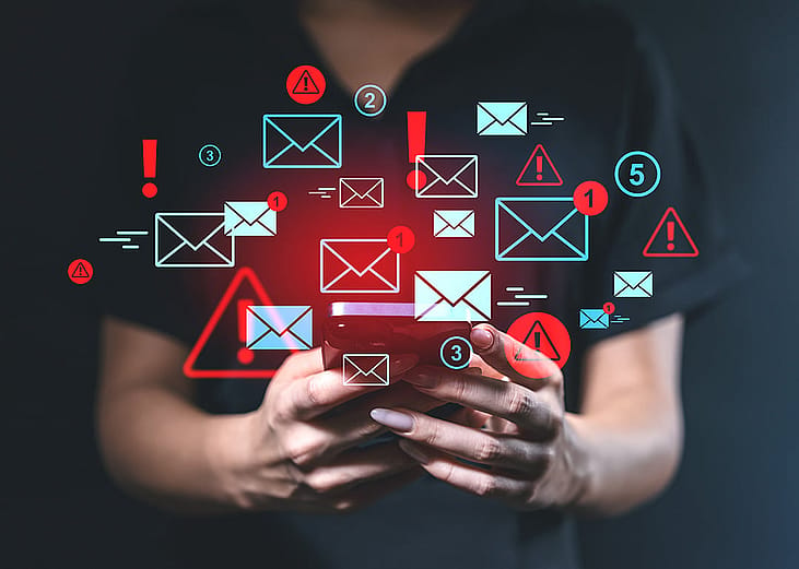 Person using a smartphone illustrated with blue and red email alert graphics.