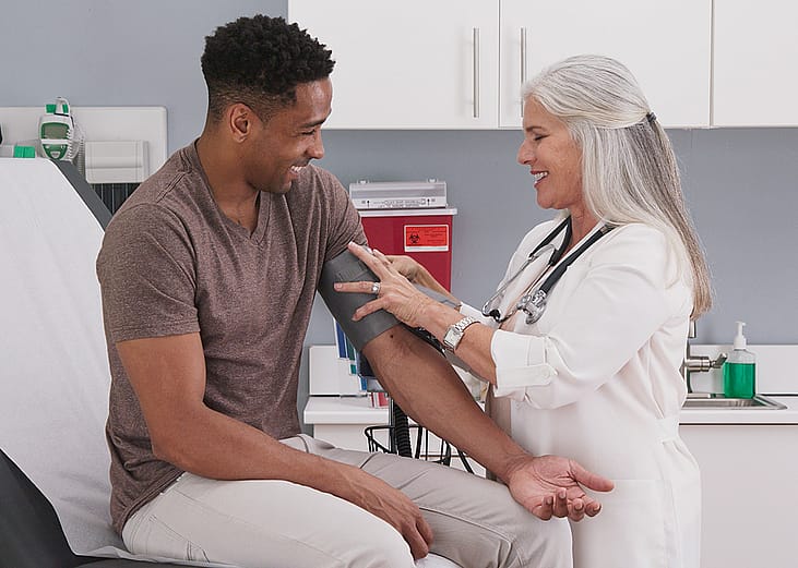 A physician checking her patient's blood pressure.