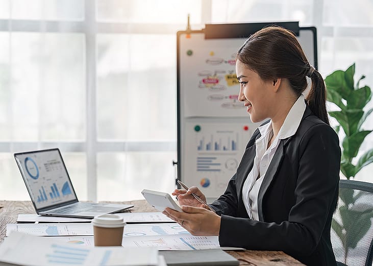 A business woman reviewing finance reports at work.
