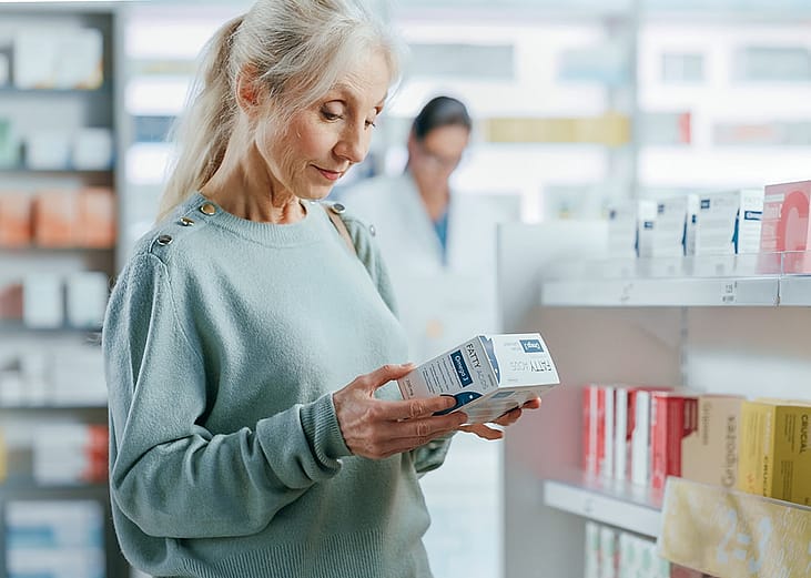 A senior woman buying a product at the pharmacy.