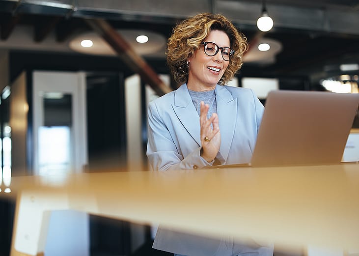 A businesswoman on a video call in an office.